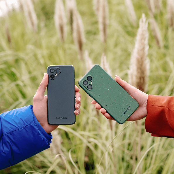 Two hands holding Fairphone models—one dark gray and the other green